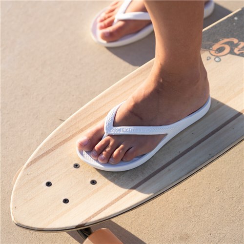 Riding a skateboard with white thongs